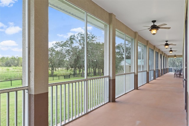 unfurnished sunroom with ceiling fan and a wealth of natural light