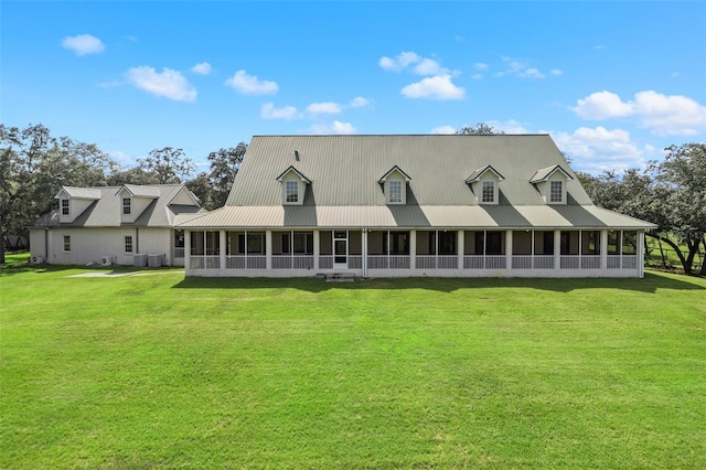 rear view of house featuring a sunroom and a lawn