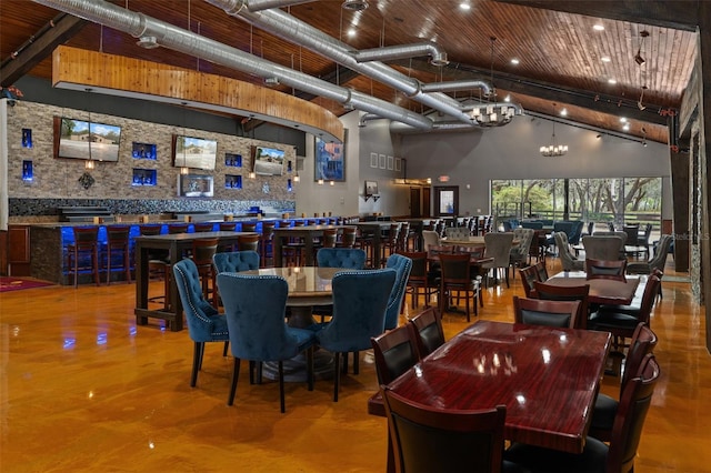 dining room featuring rail lighting, an inviting chandelier, and a high ceiling