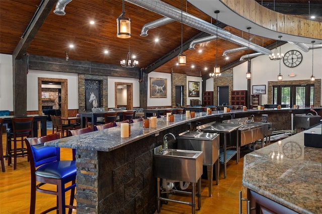 bar featuring high vaulted ceiling, a notable chandelier, decorative light fixtures, beam ceiling, and wooden ceiling