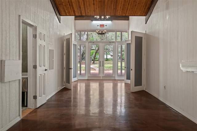 interior space with wooden ceiling, dark hardwood / wood-style floors, a chandelier, and a high ceiling