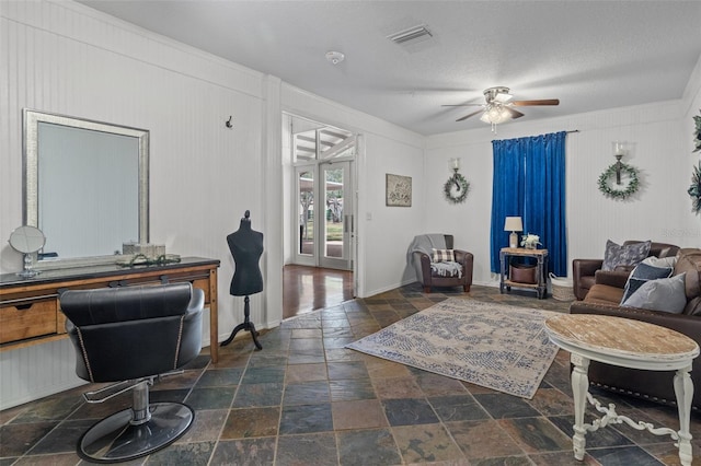 living room with ceiling fan, dark tile floors, french doors, and a textured ceiling