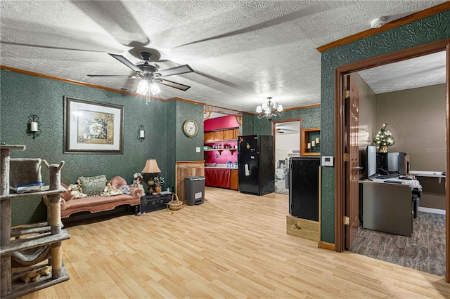 living room featuring hardwood / wood-style floors, ornamental molding, ceiling fan with notable chandelier, and a textured ceiling