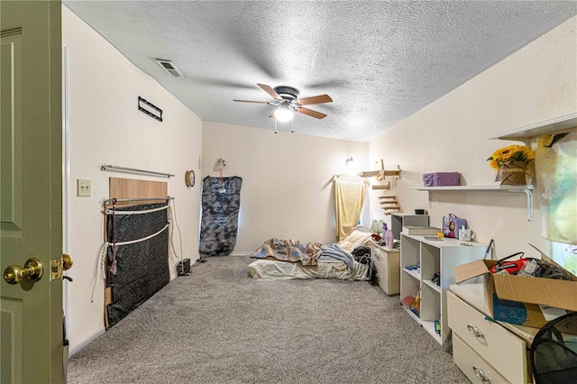 bedroom with a textured ceiling, ceiling fan, and carpet flooring