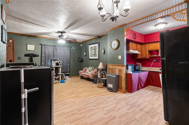 kitchen featuring ceiling fan with notable chandelier, black refrigerator, light hardwood / wood-style floors, and a textured ceiling