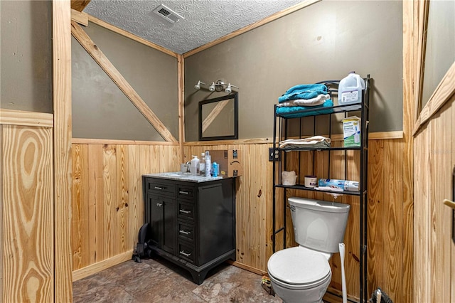 bathroom featuring crown molding, toilet, tile flooring, vanity, and wooden walls