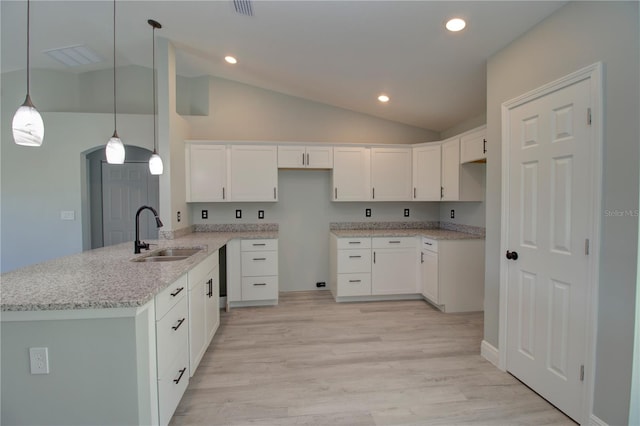 kitchen featuring white cabinetry, decorative light fixtures, sink, and vaulted ceiling