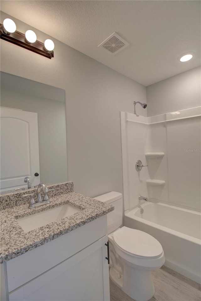 full bathroom featuring vanity, toilet, wood-type flooring, and washtub / shower combination