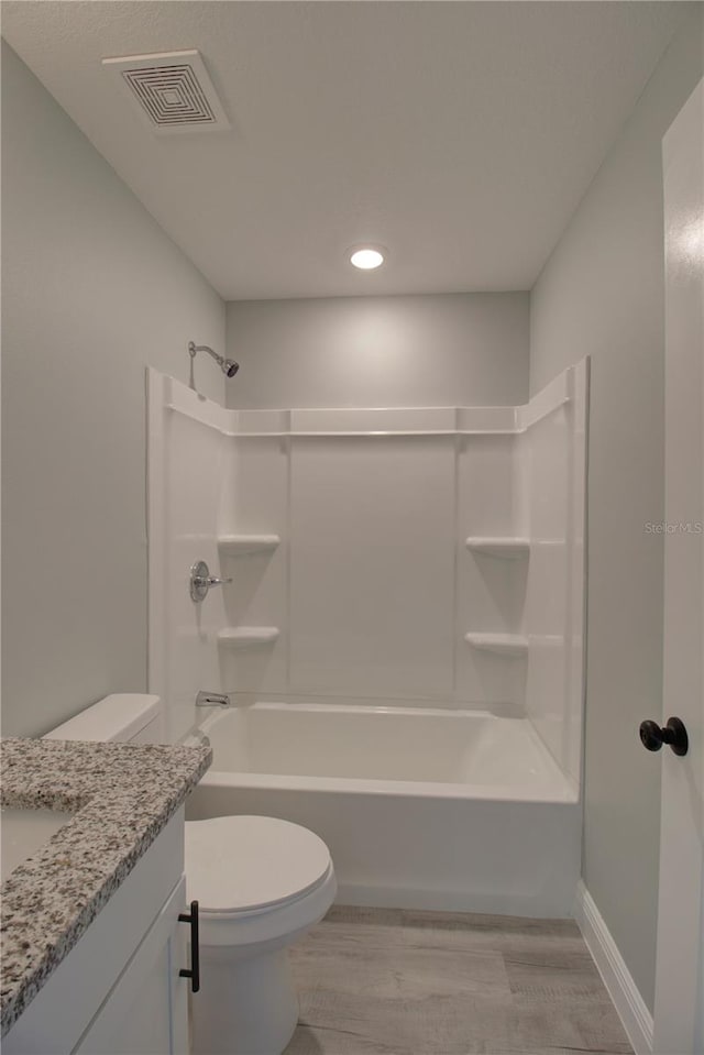 full bathroom with vanity, tub / shower combination, hardwood / wood-style flooring, and toilet