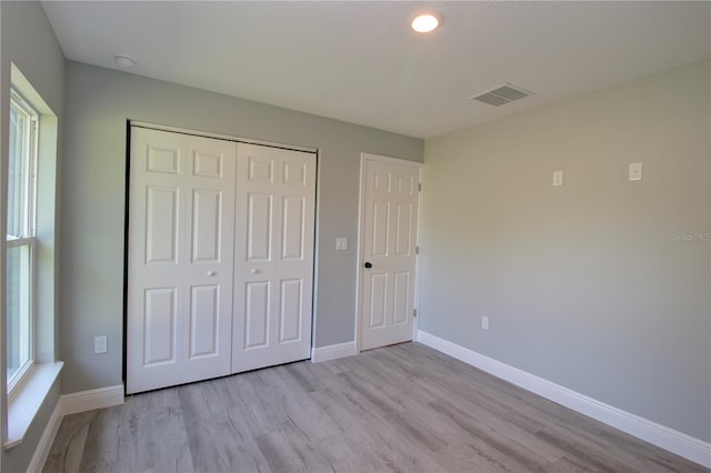 unfurnished bedroom featuring a closet and light wood-type flooring