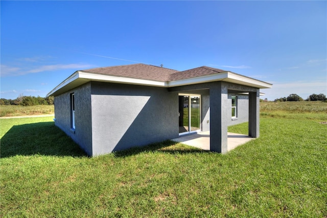 rear view of house with a patio and a lawn