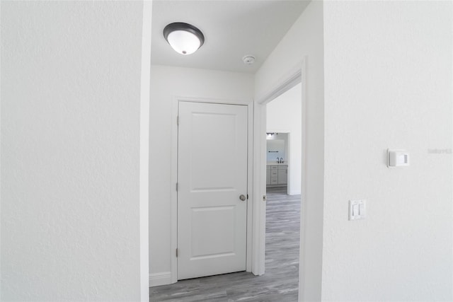 corridor featuring baseboards and wood finished floors