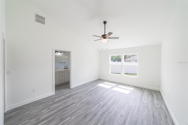 unfurnished bedroom featuring a sink, baseboards, visible vents, and wood finished floors