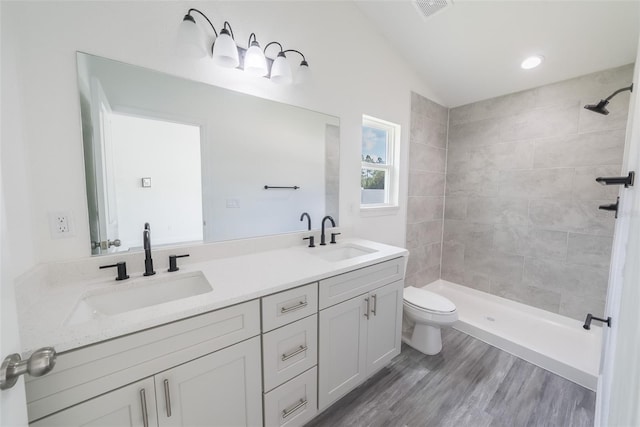 bathroom with visible vents, a tile shower, and a sink