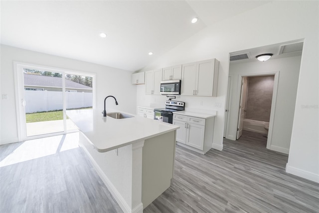 kitchen with range with electric stovetop, stainless steel microwave, visible vents, vaulted ceiling, and a sink