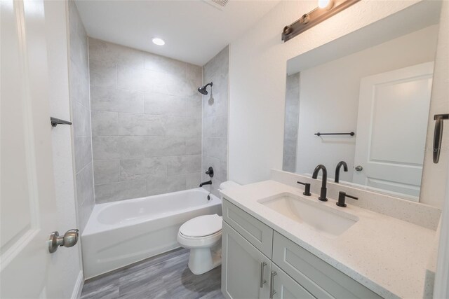 full bathroom with toilet, bathtub / shower combination, wood finished floors, and vanity