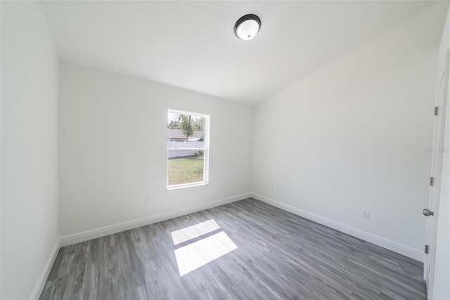 spare room featuring baseboards and wood finished floors