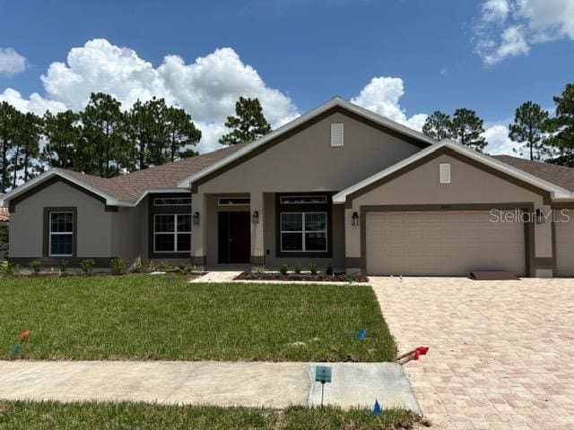 view of front of house featuring a garage and a front lawn