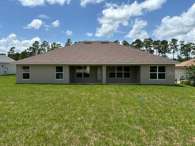 rear view of property featuring a lawn