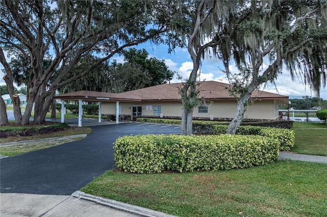 ranch-style house featuring a front yard and a carport