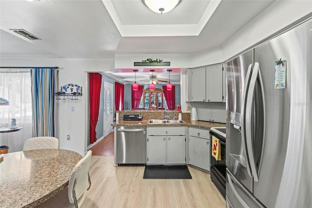 kitchen with gray cabinetry, pendant lighting, sink, light hardwood / wood-style floors, and stainless steel appliances