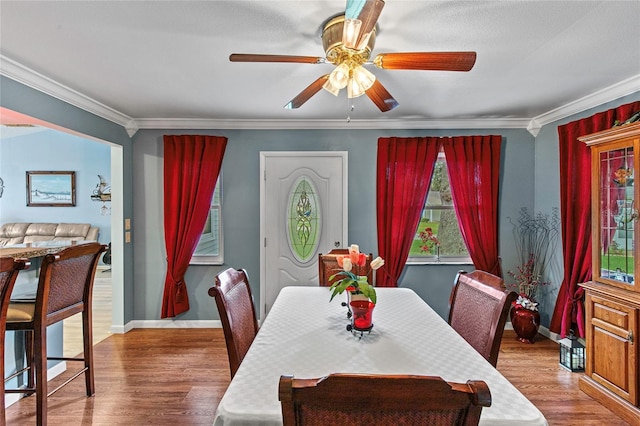 dining area featuring ceiling fan, wood-type flooring, and crown molding