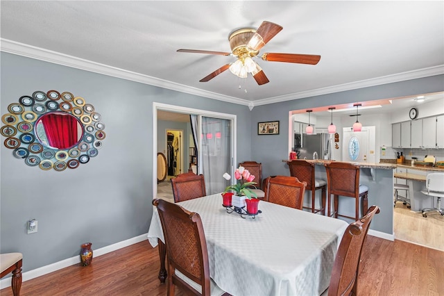 dining room with dark hardwood / wood-style floors, ceiling fan, and crown molding