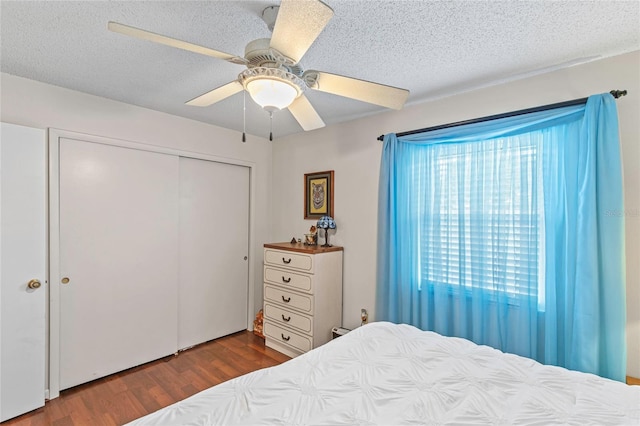 bedroom featuring ceiling fan, a closet, a textured ceiling, and hardwood / wood-style flooring