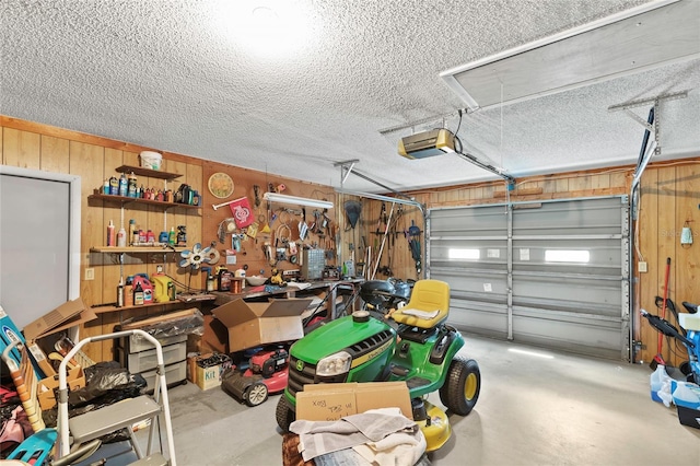 garage with a workshop area, a garage door opener, and wooden walls