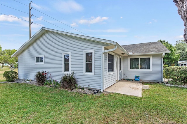 back of property featuring a patio area and a lawn