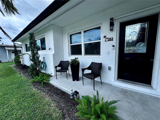 doorway to property featuring a yard and a patio