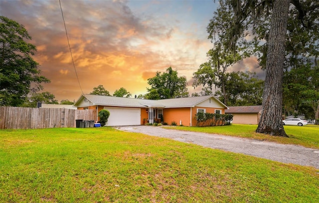 single story home with a garage and a yard