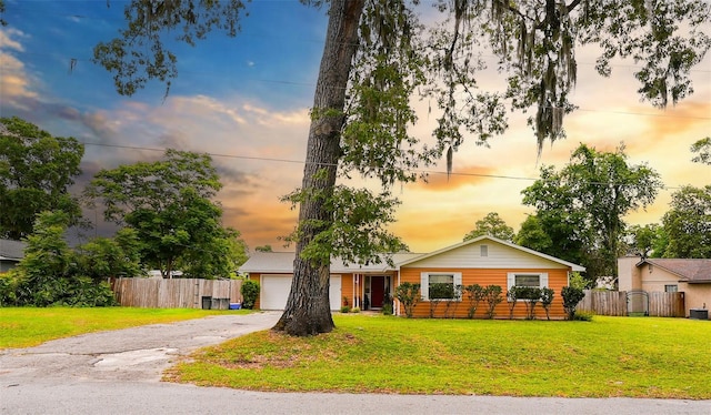 ranch-style house with a garage and a lawn