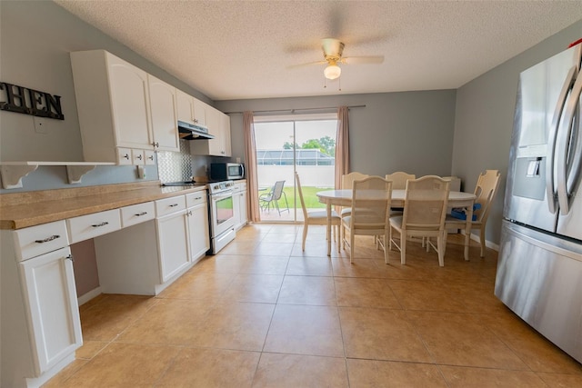 kitchen with white cabinets, ceiling fan, light tile floors, and stainless steel appliances