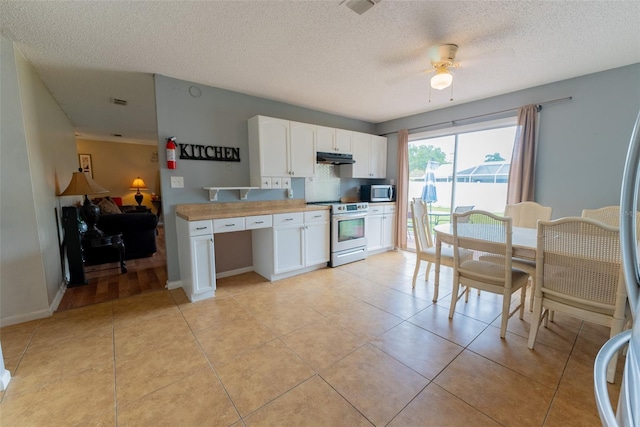 kitchen featuring ceiling fan, a textured ceiling, electric range oven, light tile flooring, and white cabinetry