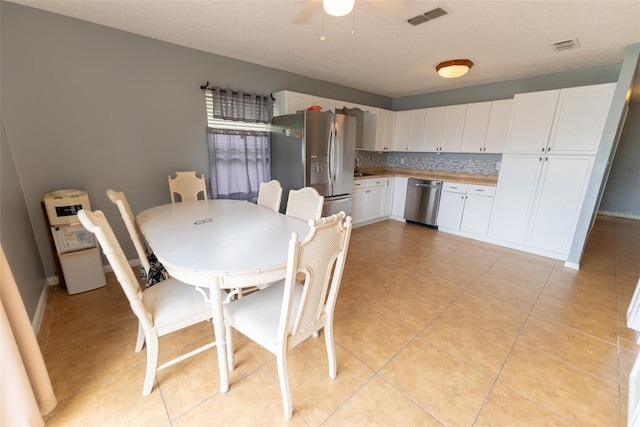 tiled dining space featuring ceiling fan and a textured ceiling