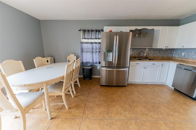 dining area featuring sink and light tile floors