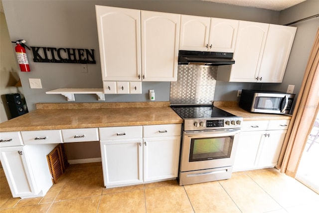 kitchen featuring appliances with stainless steel finishes, light tile floors, and white cabinets