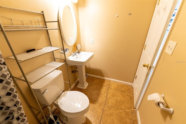 bathroom featuring toilet, tile flooring, and sink