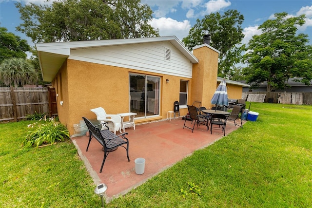 rear view of property featuring a patio area and a lawn