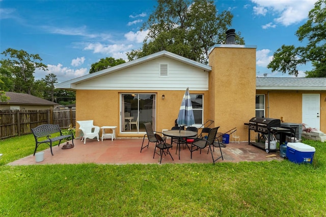 back of property with a lawn and a patio area