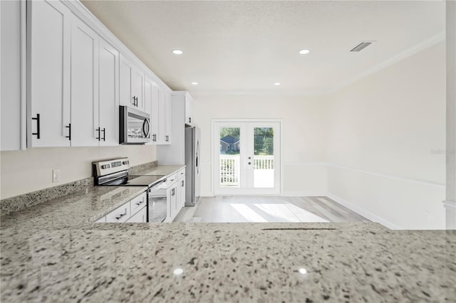 kitchen featuring appliances with stainless steel finishes, white cabinetry, french doors, and light stone counters