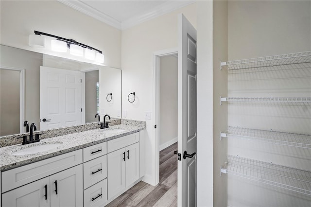 bathroom featuring hardwood / wood-style flooring, vanity, and ornamental molding