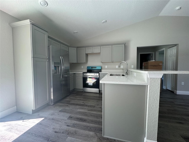 kitchen featuring sink, vaulted ceiling, appliances with stainless steel finishes, kitchen peninsula, and gray cabinets