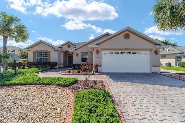 single story home featuring a garage and central AC unit