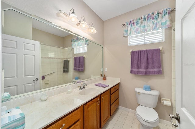 bathroom with tile floors, plenty of natural light, vanity, and toilet