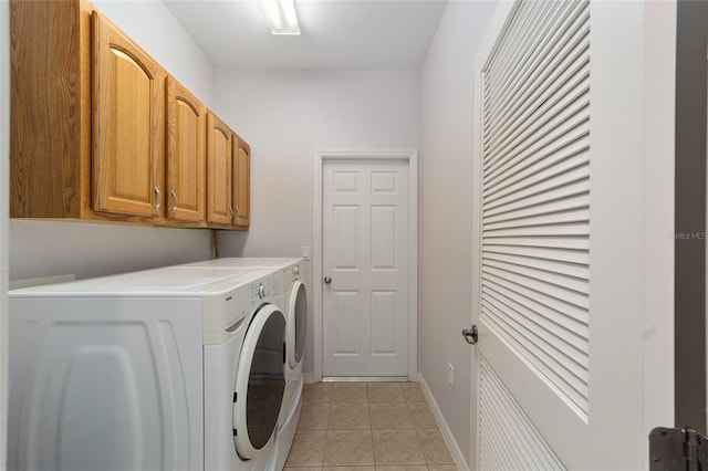 laundry room with independent washer and dryer, cabinets, and light tile floors