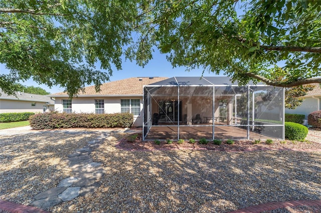 single story home featuring glass enclosure and a patio