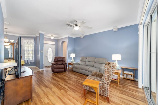 living room with ornamental molding, light hardwood / wood-style flooring, and ceiling fan