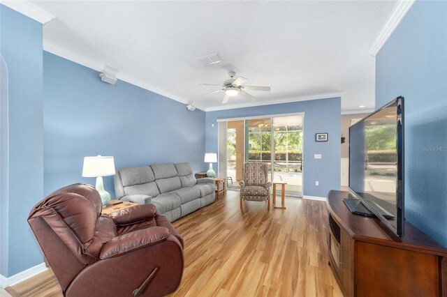 living room with ornamental molding, light hardwood / wood-style flooring, and ceiling fan